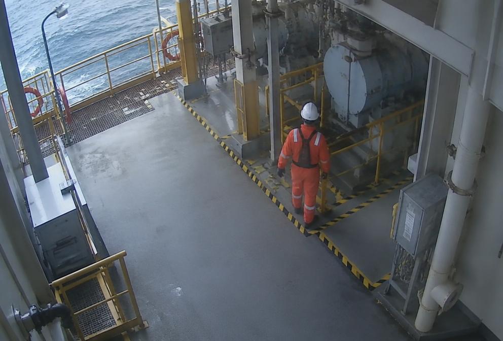 Worker entering a permit-controlled offshore module highlighted by AI