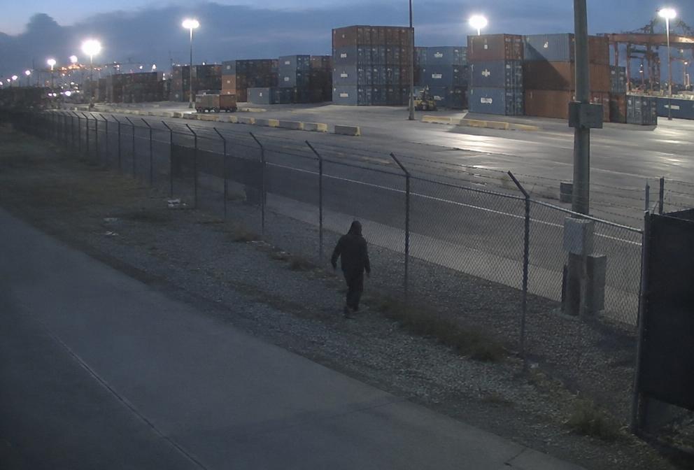 Port perimeter fence at night with an intruder flagged by AI